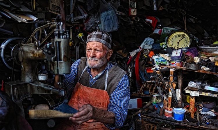 Old Turkish man manages a shoe repair shop