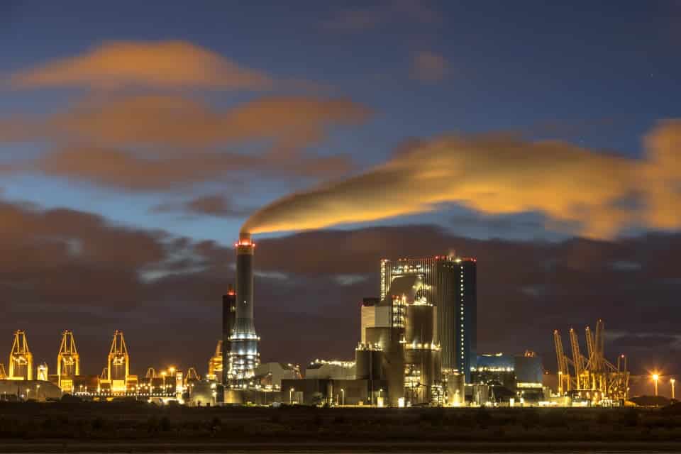 Industrial landscape with illuminated clouds at night