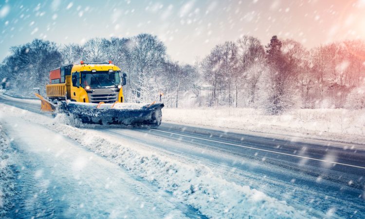 Snow plow truck cleaning snowy road