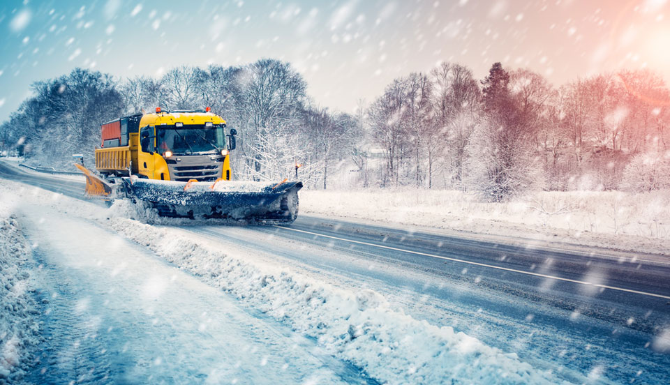 Snow plow truck cleaning snowy road