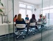 Diverse Business Team Discussing Projects in a Modern Glass Office.